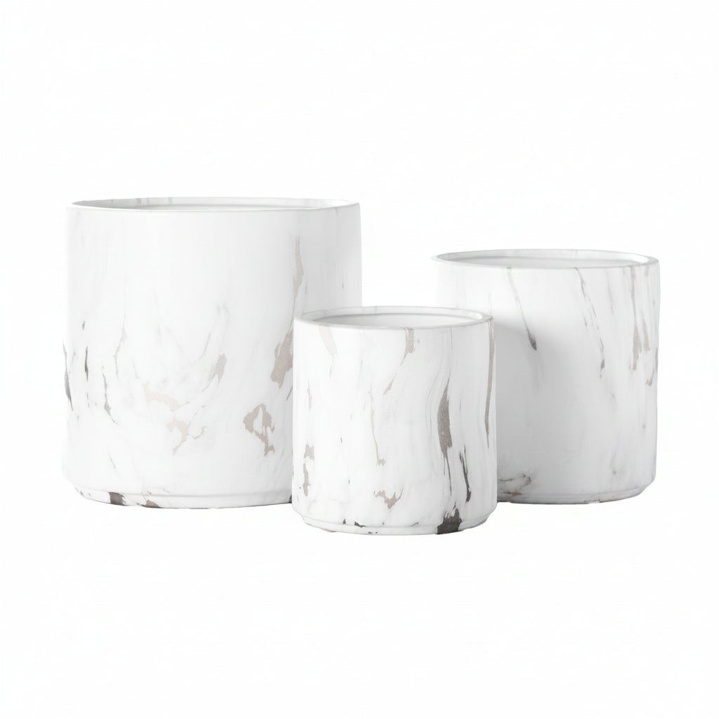 A set of three white ceramic round pots with a matte finish and abstract designs