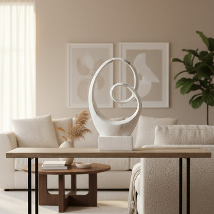 A white ceramic sculpture with a polished chrome finish and abstract design featuring gray marbleized streaks on a glossy base.