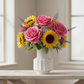 A vibrant floral arrangement featuring pink roses, yellow sunflowers, and purple lavender sprigs in a white ribbed ceramic vase, displayed on a light wood table in front of a softly blurred window.