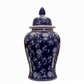 A traditional Chinese porcelain ginger jar with a lid, featuring a deep cobalt blue glaze and intricate white floral patterns, set against a plain white background.