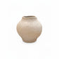 A small, rounded ceramic vase with a wide, shallow opening, featuring a textured, speckled beige glaze on a solid white background.