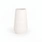 A matte white ceramic round cylinder vase with debossed banded line column design and a tapered bottom base.