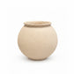 A round, textured ceramic pot in a light sandy beige color, photographed against a seamless white background.