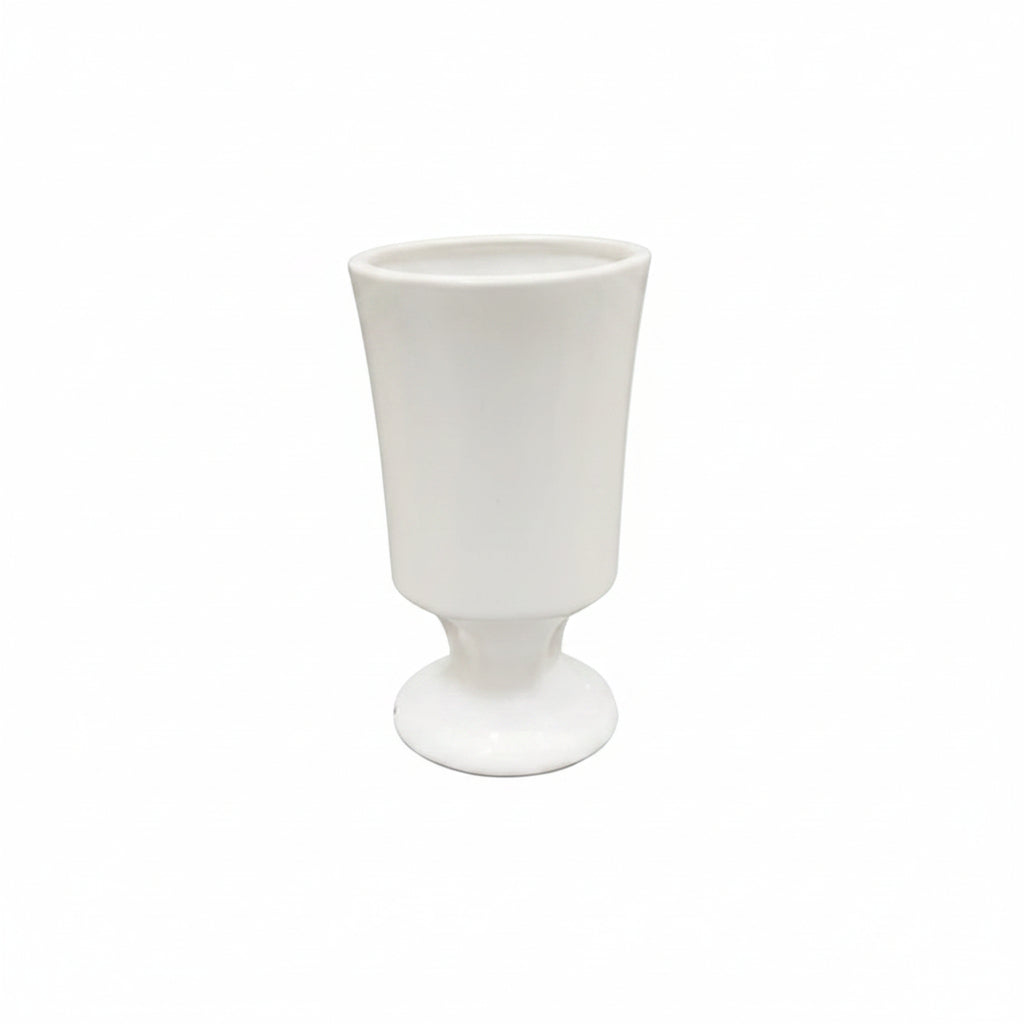 A white ceramic goblet or tumbler with a flared rim and a short pedestal base, shown against a plain white background.