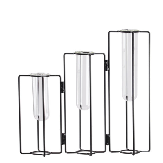 Set of three black metal and glass candle holders on a white background