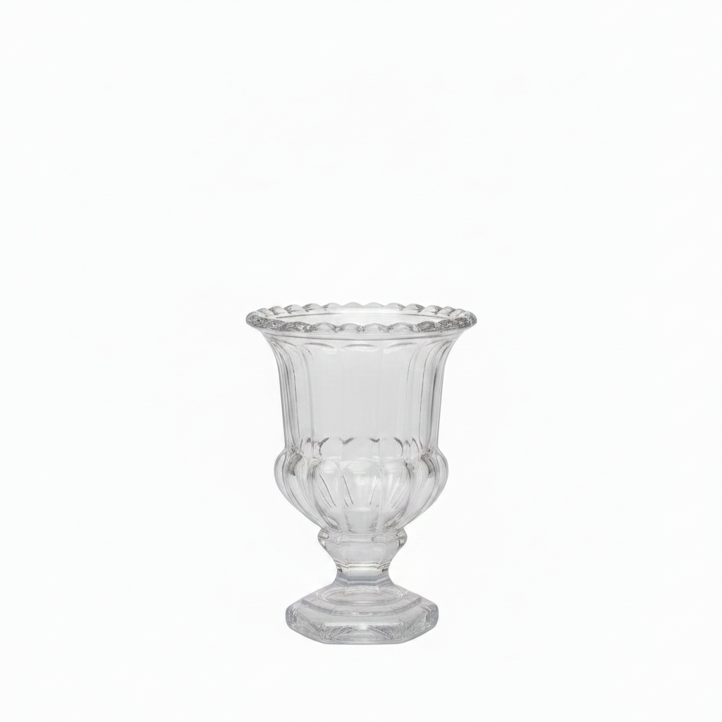 A clear glass pedestal cup with a flared rim, subtle scalloped edge detailing, and a fluted body, shown on a plain white background.