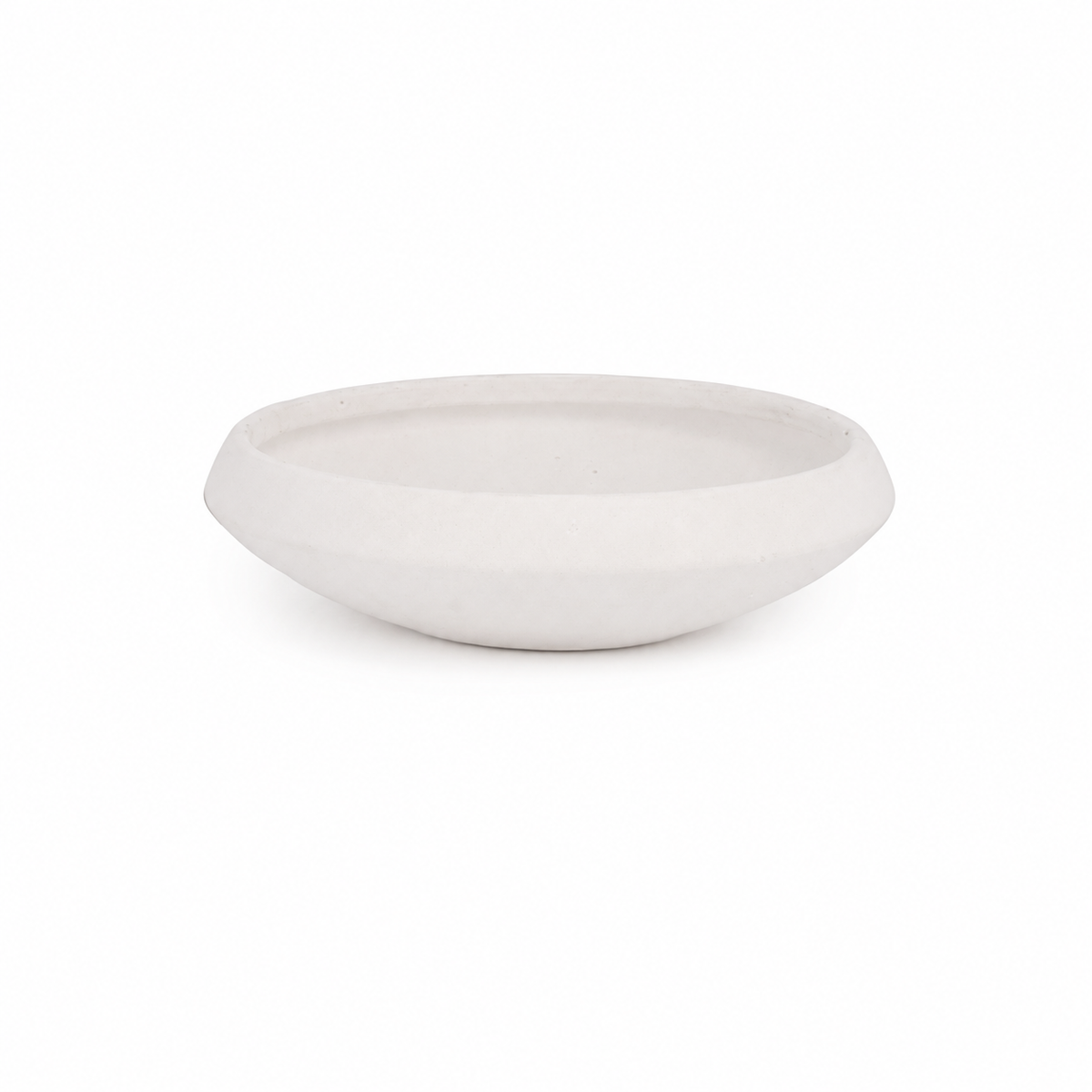 A minimalist, shallow oval ceramic bowl in a matte off-white finish, photographed against a seamless white background.