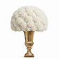 A large, dense bouquet of white flowers arranged in a polished gold pedestal vase against a clean white background.